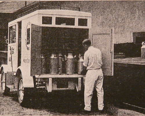 Sales photo loading milk cans into truck from rear doors